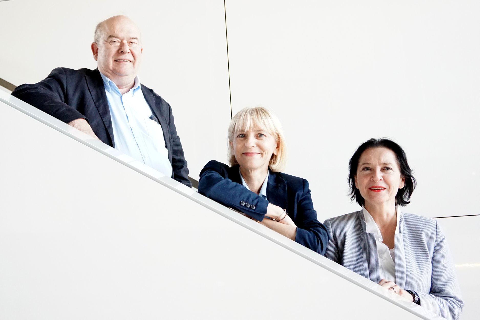 trójka młodych ludzi w średnim wieku: od lewej mężczyzna, a obok niego dwie kobiety, blondynka i brunetka